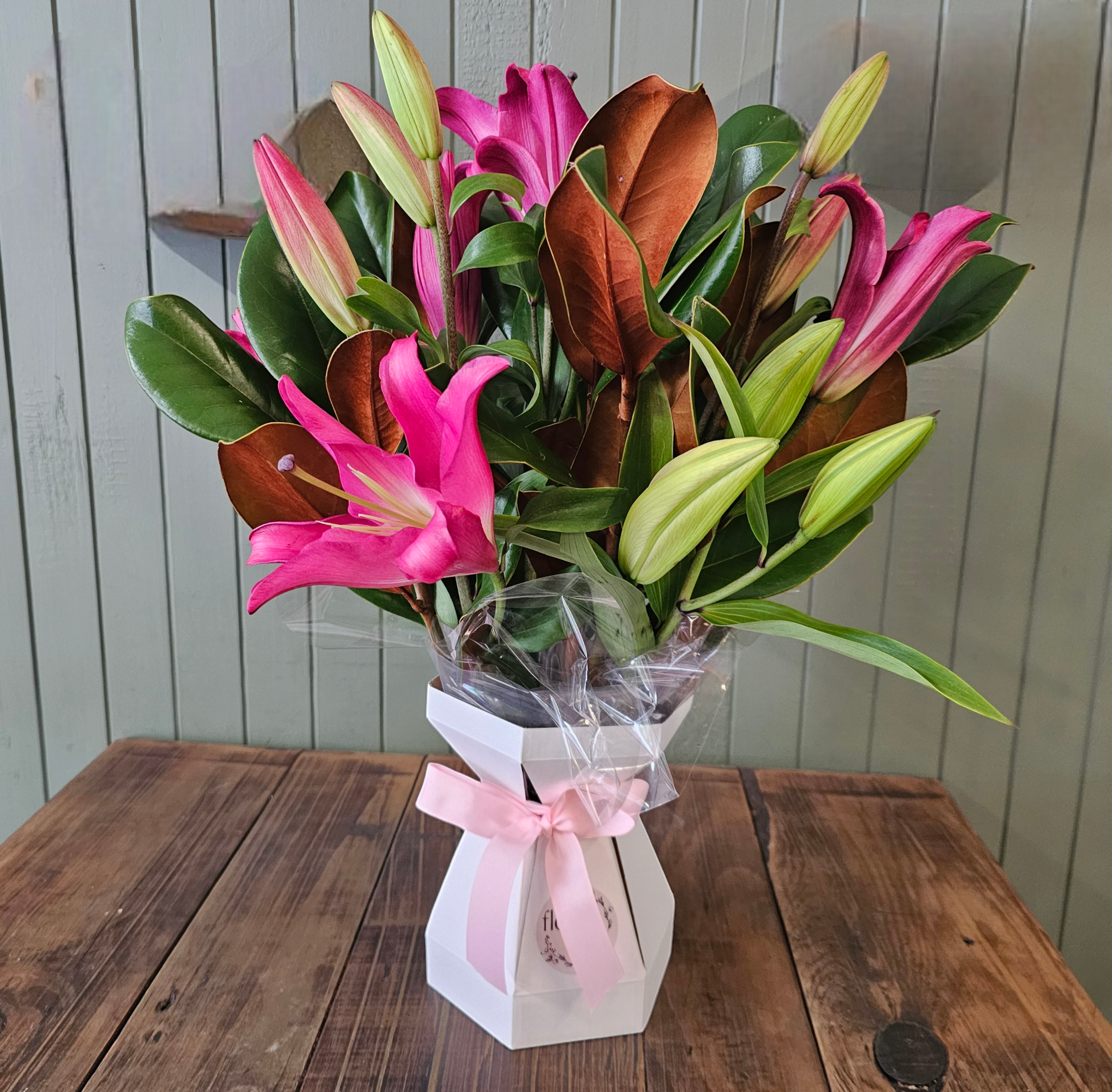 Oriental Lilies arranged in a box with foliage